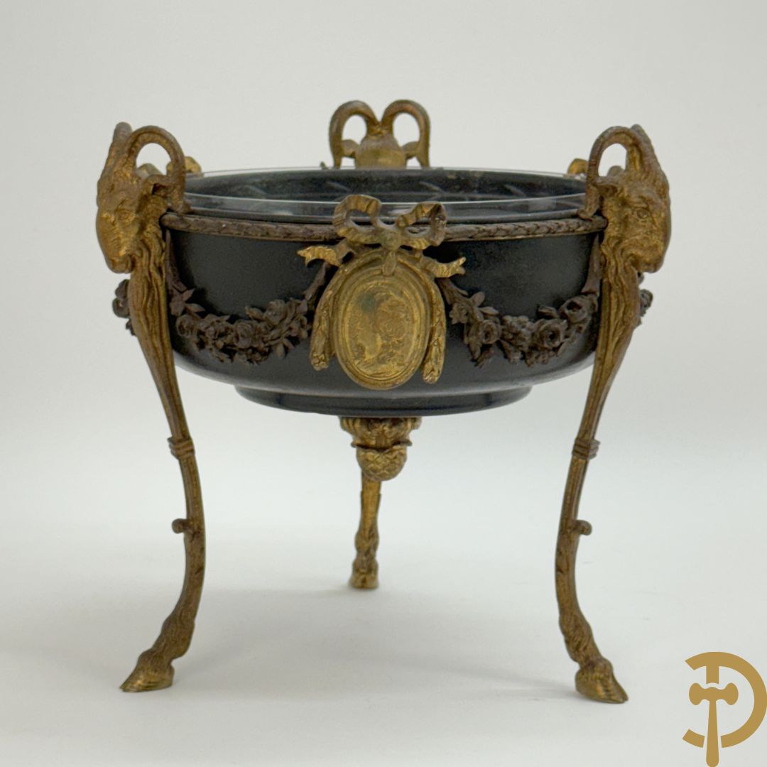 Bronzen coupe op 3 bokkepoten met ramskoppen  bezet en verbonden door guirlandes met medaillon