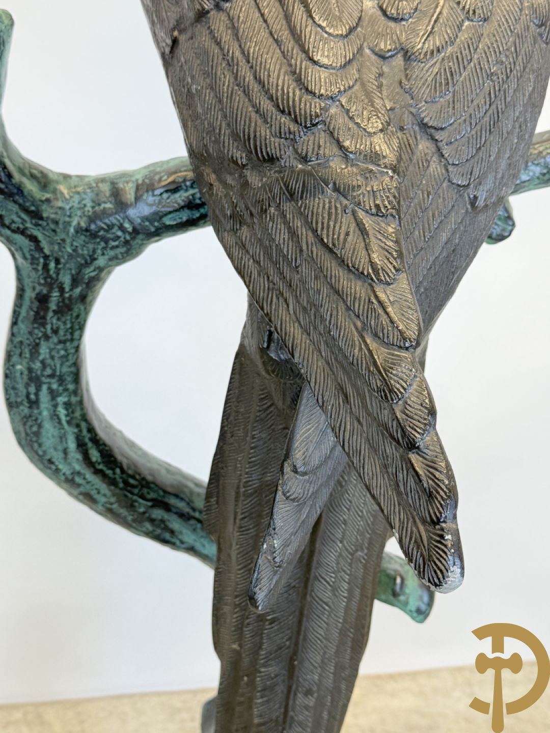 Metalen gepatineerde papegaai op boomstronk