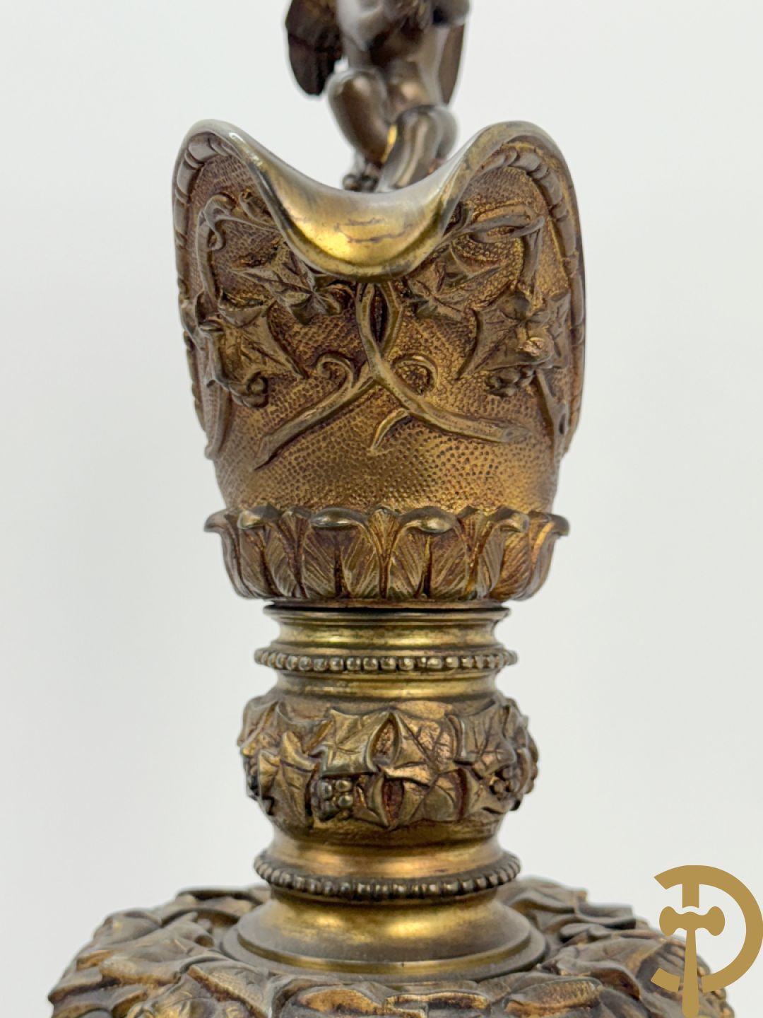 Paar bronzen schenkkannen met basrelief van putti en accanthusranken