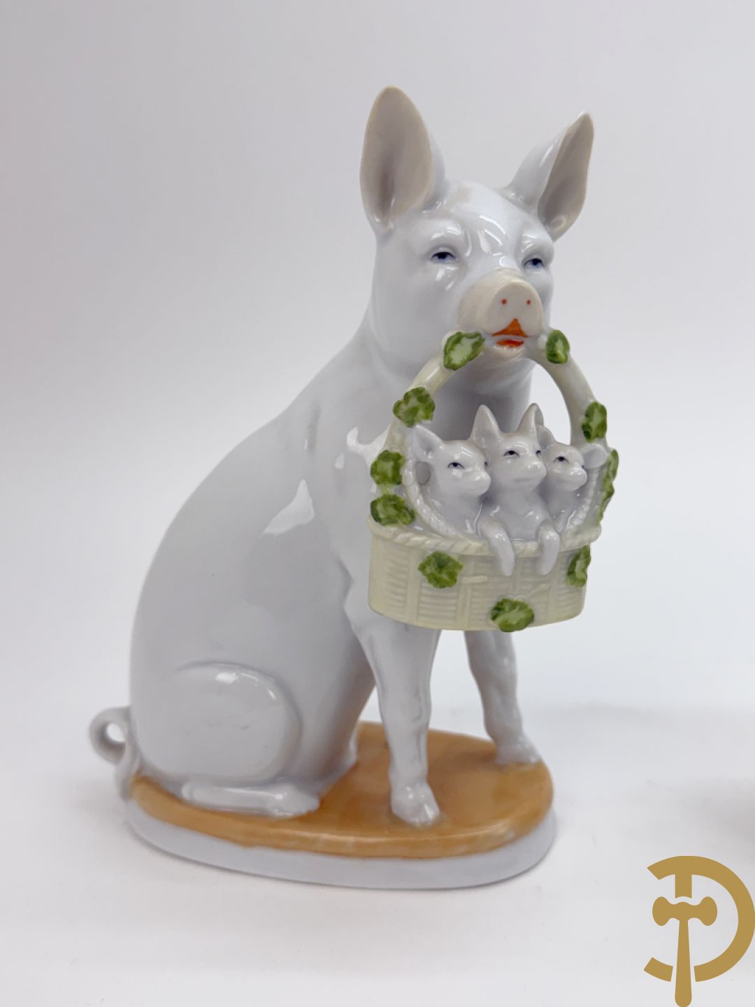 Koppel porseleinen beeldjes met varkens houdende een mandje met biggetjes