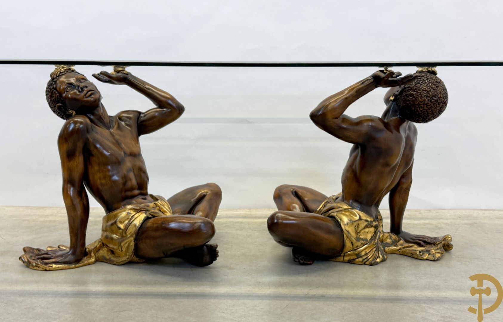 Salontafel met een paar moren met vergulde lendendoek dragende een achthoekig geslepen glazen blad