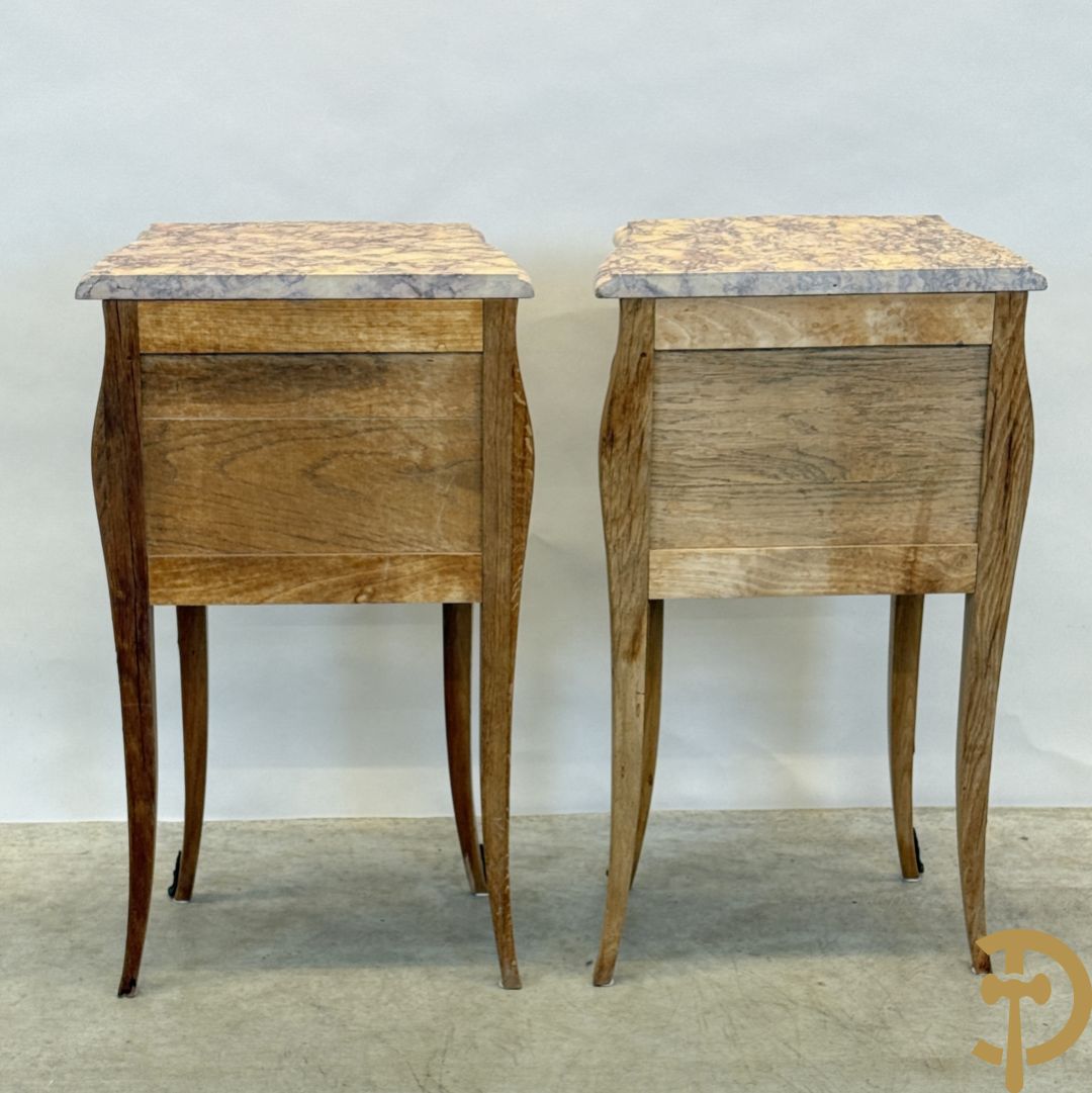 Paar notelaren bijzetkastjes met 2 lades en bezet met bronsbeslag, bovenaan met marmeren blad, op voluutvormige poten