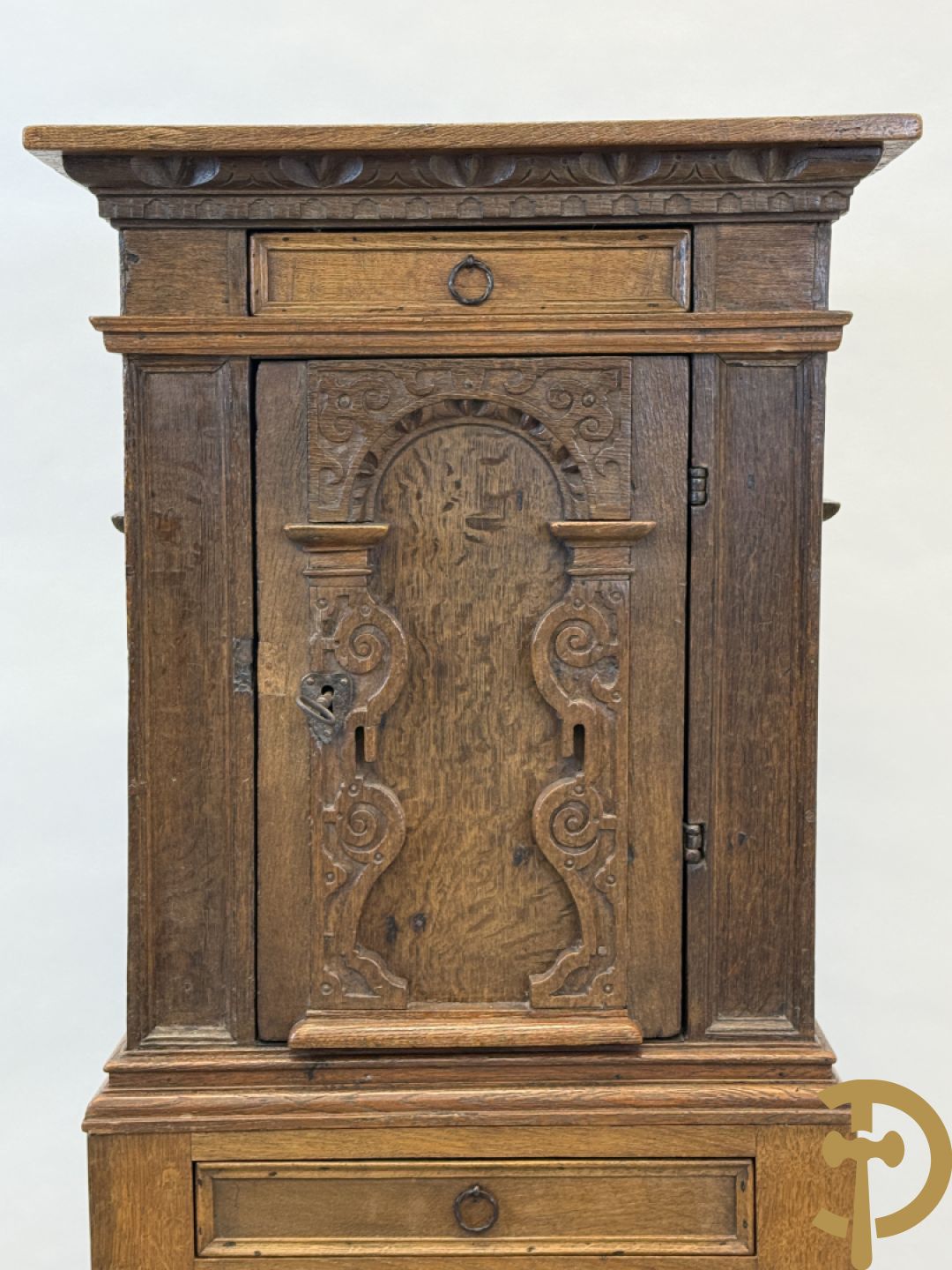 Massief eiken ééndeurskast op onderstel met lade bovenaan, lade onderaan, sculptuur in zijkant en deur