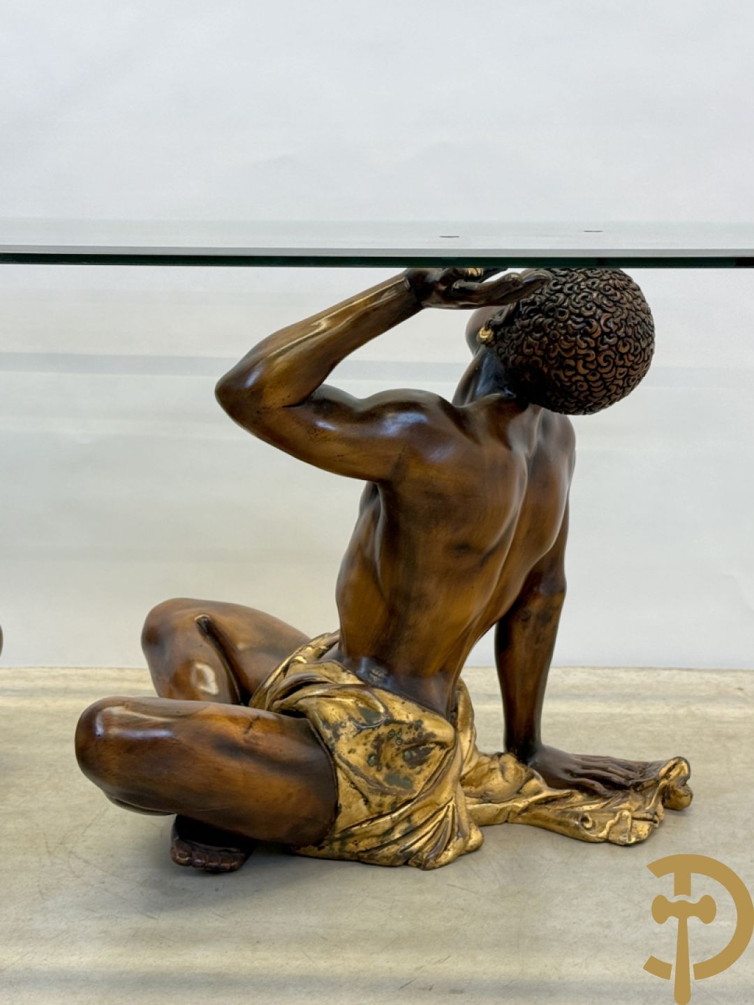 Salontafel met een paar moren met vergulde lendendoek dragende een achthoekig geslepen glazen blad