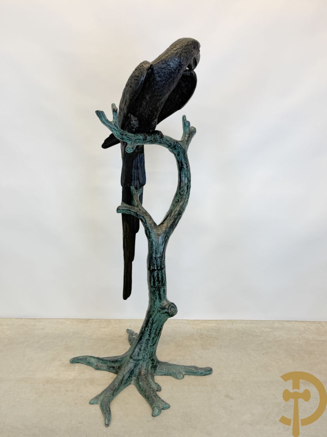 Metalen gepatineerde papegaai op boomstronk