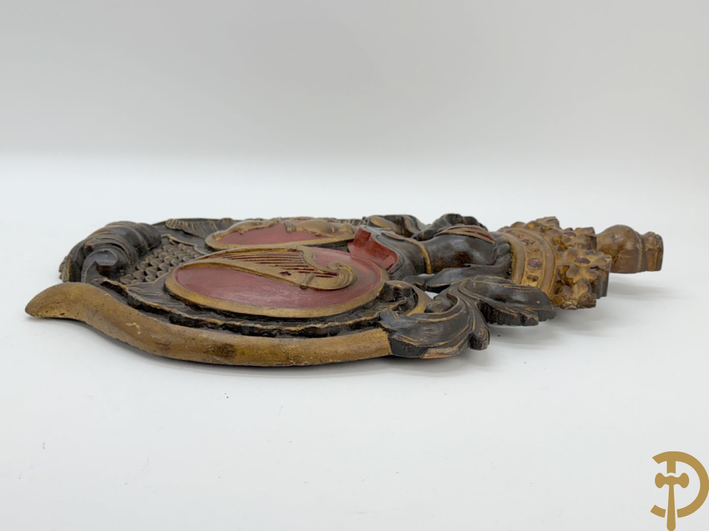 Houtgesculpteerd wapenschild met cartouche bovenaan en embleem met kannen en harp