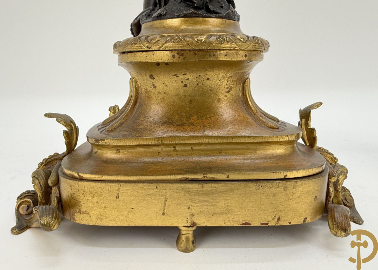 Driedelige bronzen garnituur bestaande uit middenstuk met bronzen vuurvergulde klok, Daubrée gemerkt à Nancy, bovenaan bekroond met Cleopatra met drinkbeker - getekend van Cumberworth sculpteur - geflankeerd door paar cupido