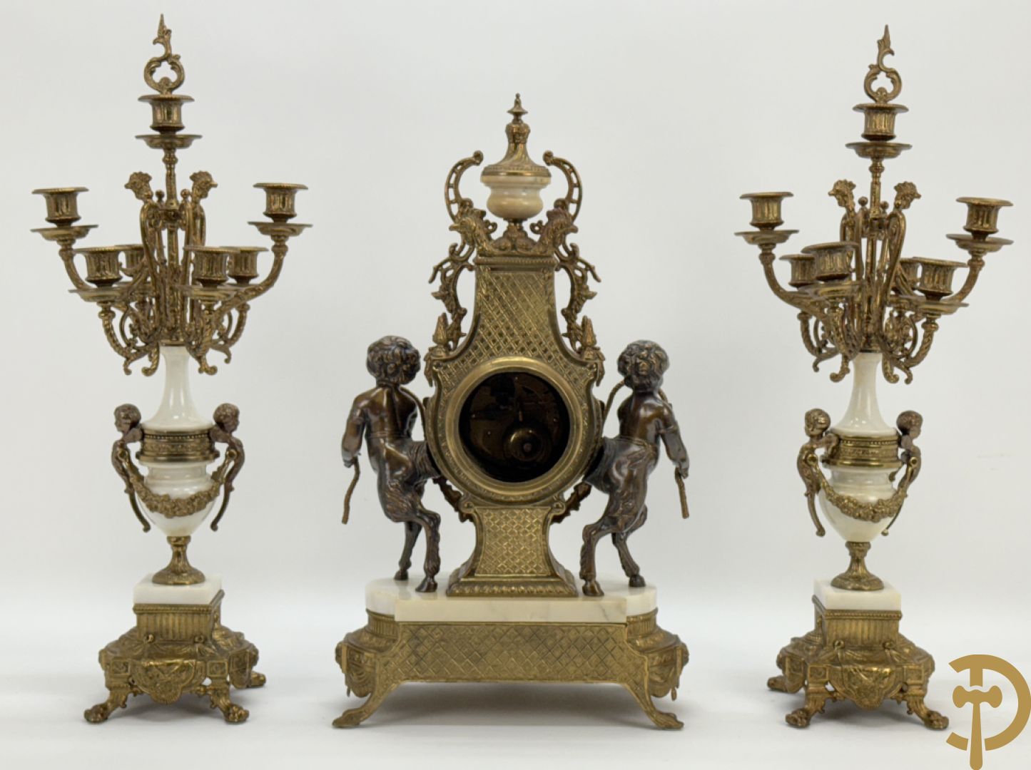 Driedelige koperen garnituur, centraal met harp geflankeerd door paar cupido