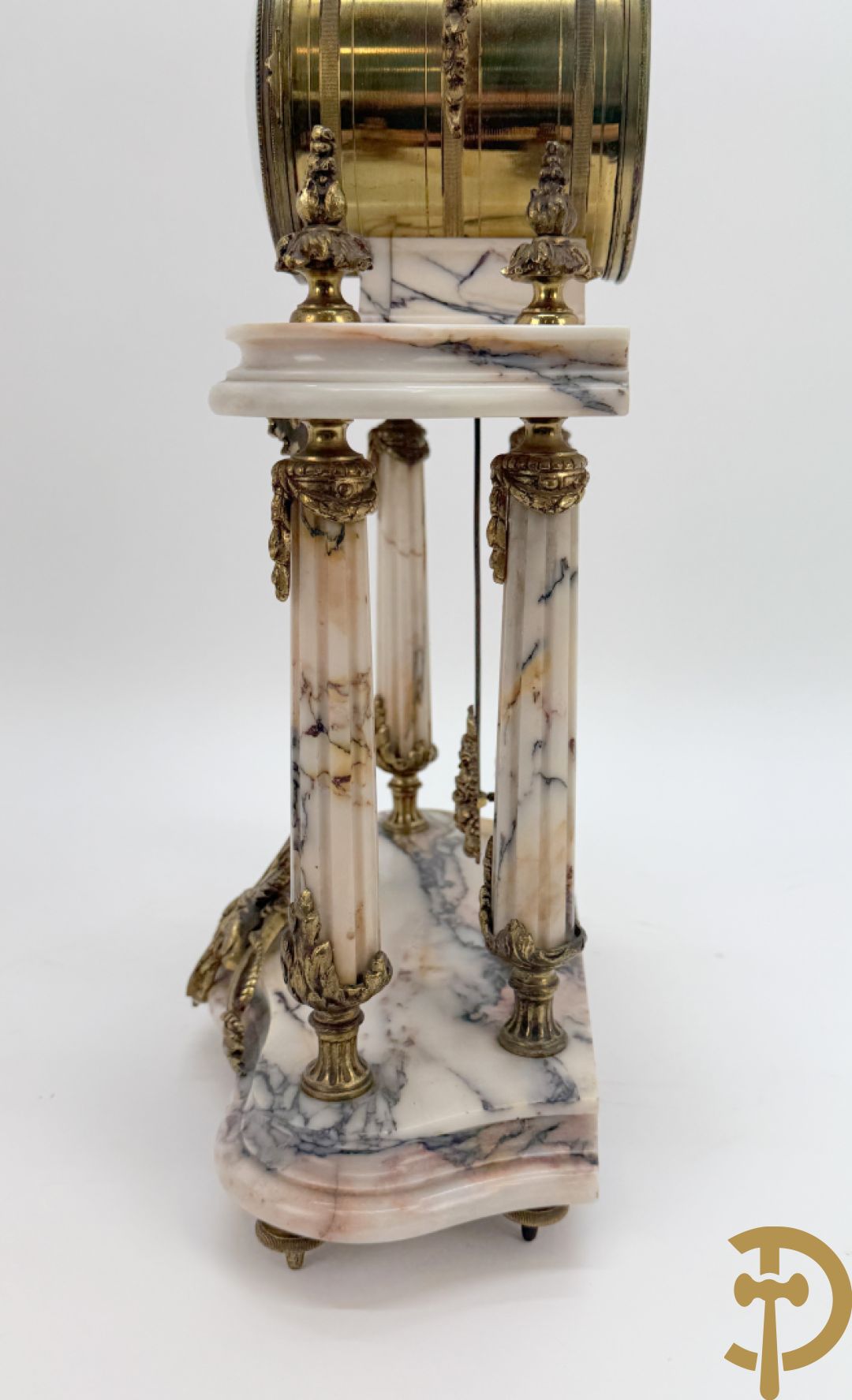 Driedelige wit marmeren garnituur bestaande uit vierzuilenpendule met bloemen en troffee geflankeerd door paar cassolettes met ramskoppen bezet