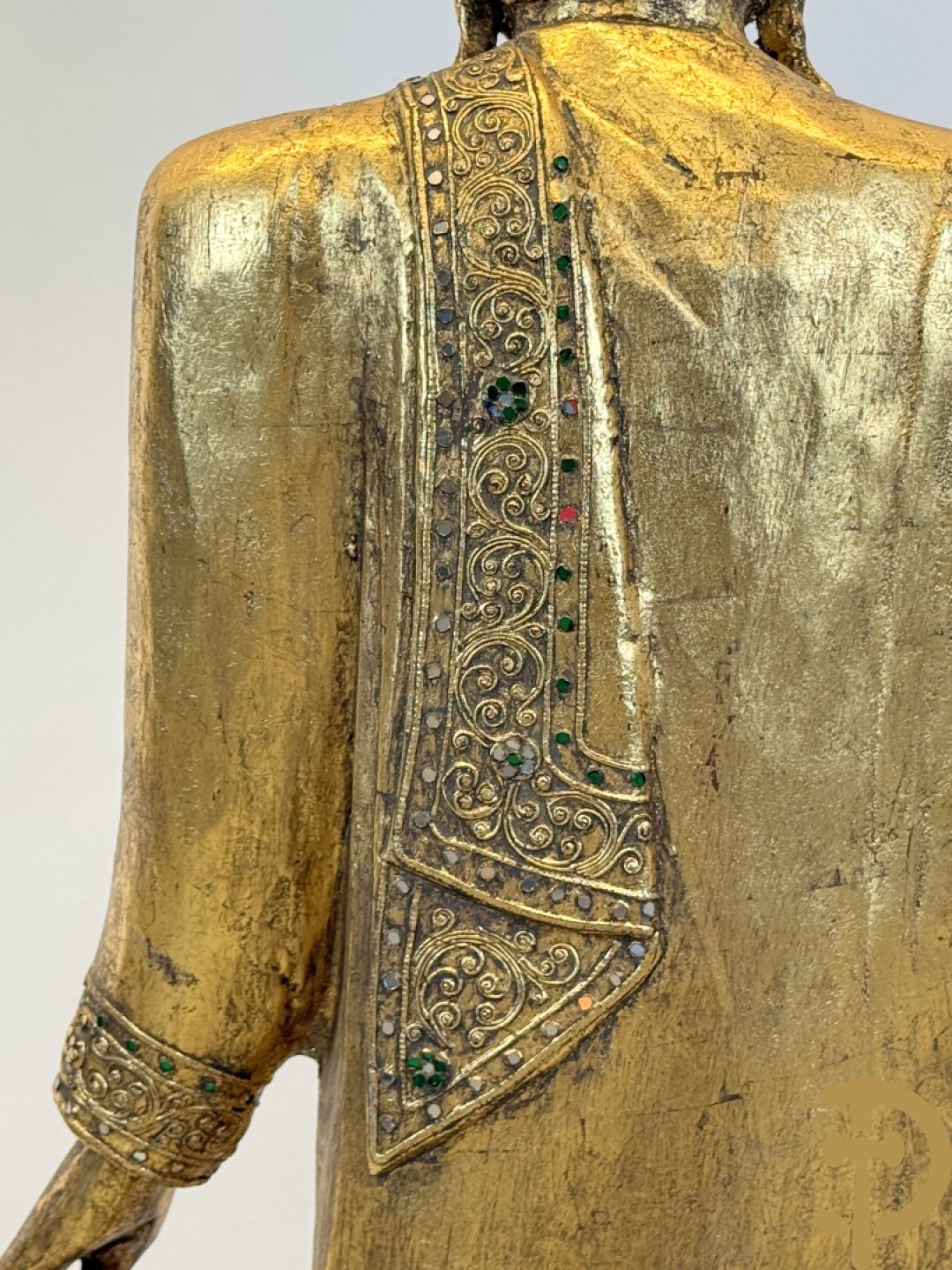 Vergulde houtgesculpteerde staande boedha bezet met spiegeltjes, op sokkel