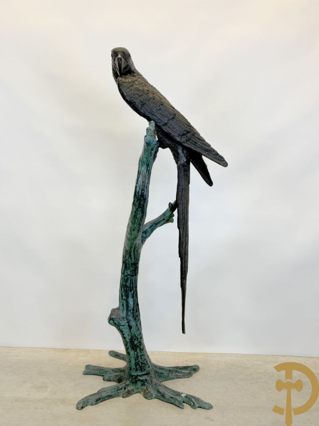 Metalen gepatineerde papegaai op boomstronk