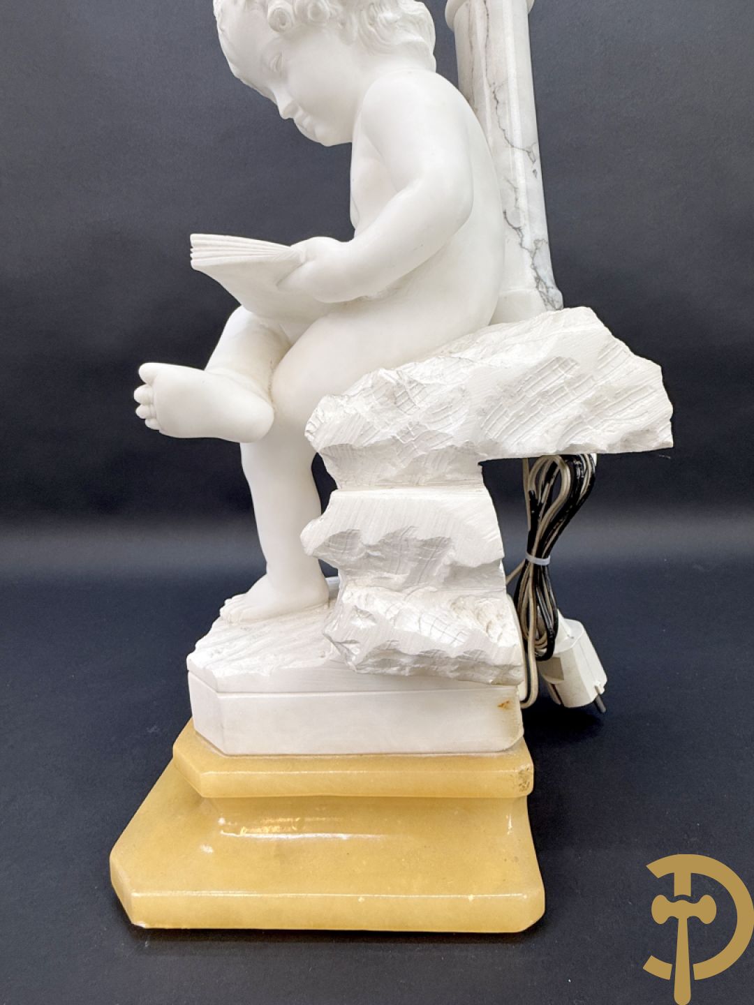 Albast beeld van jongen met boek en lamp