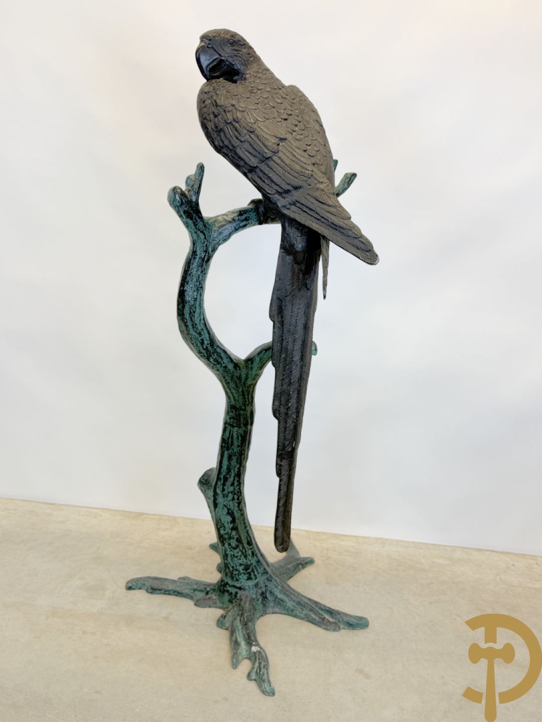 Metalen gepatineerde papegaai op boomstronk