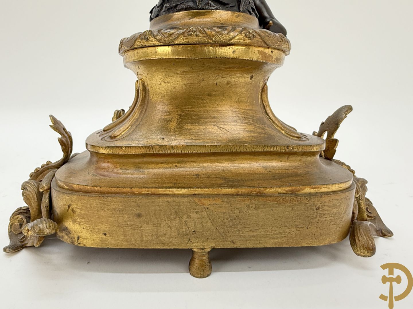 Driedelige bronzen garnituur bestaande uit middenstuk met bronzen vuurvergulde klok, Daubrée gemerkt à Nancy, bovenaan bekroond met Cleopatra met drinkbeker - getekend van Cumberworth sculpteur - geflankeerd door paar cupido