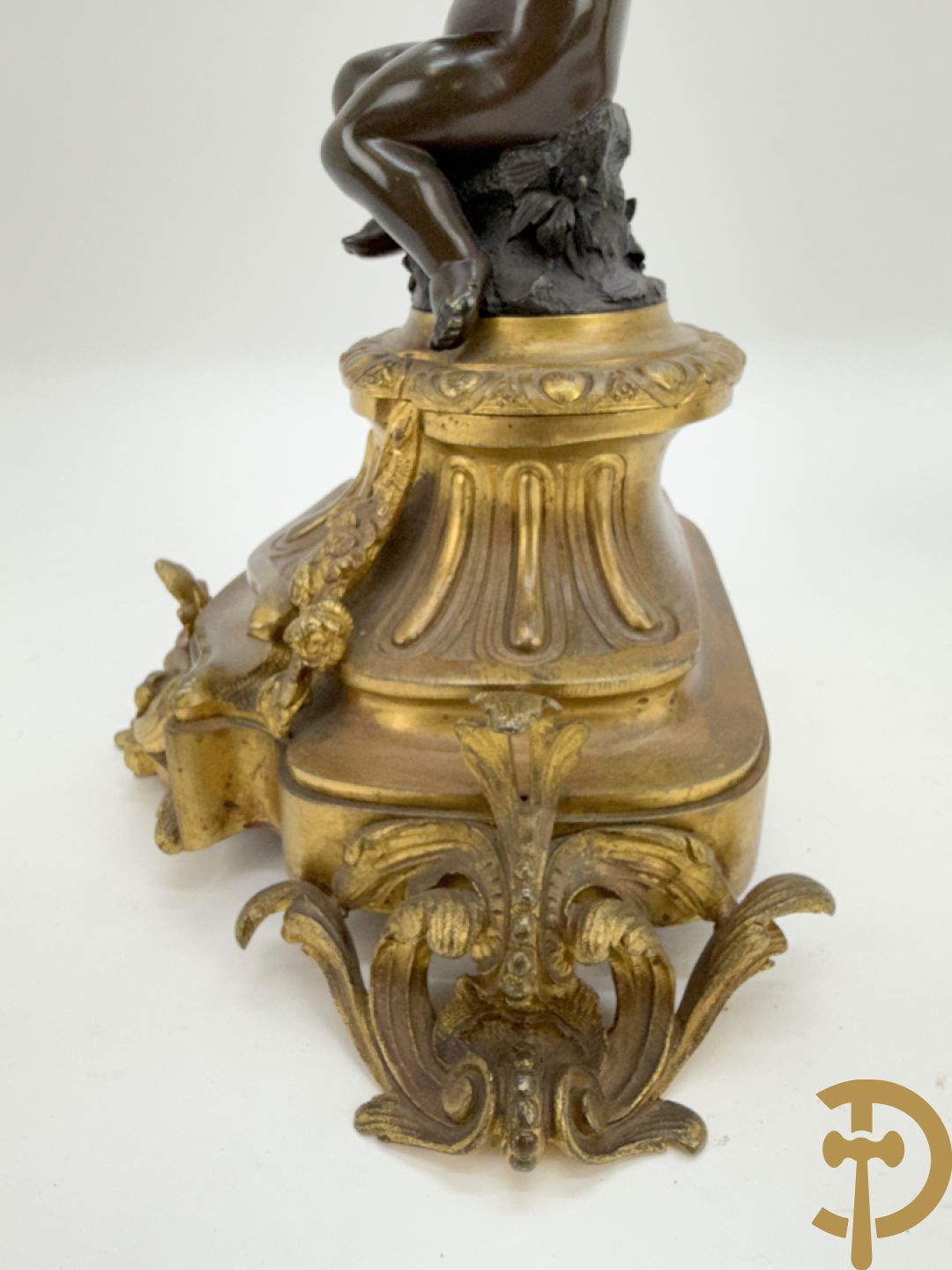 Driedelige bronzen garnituur bestaande uit middenstuk met bronzen vuurvergulde klok, Daubrée gemerkt à Nancy, bovenaan bekroond met Cleopatra met drinkbeker - getekend van Cumberworth sculpteur - geflankeerd door paar cupido