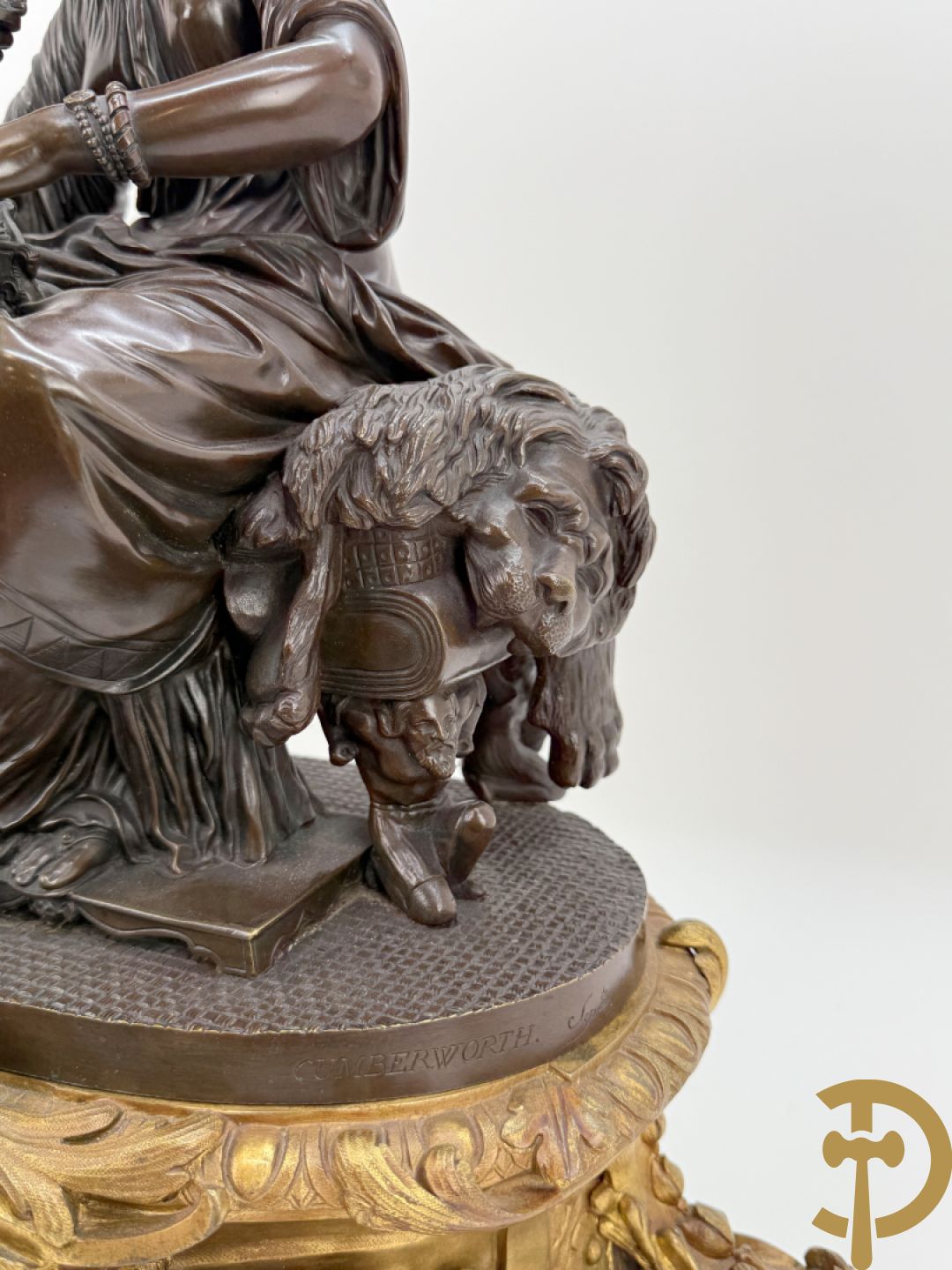 Driedelige bronzen garnituur bestaande uit middenstuk met bronzen vuurvergulde klok, Daubrée gemerkt à Nancy, bovenaan bekroond met Cleopatra met drinkbeker - getekend van Cumberworth sculpteur - geflankeerd door paar cupido