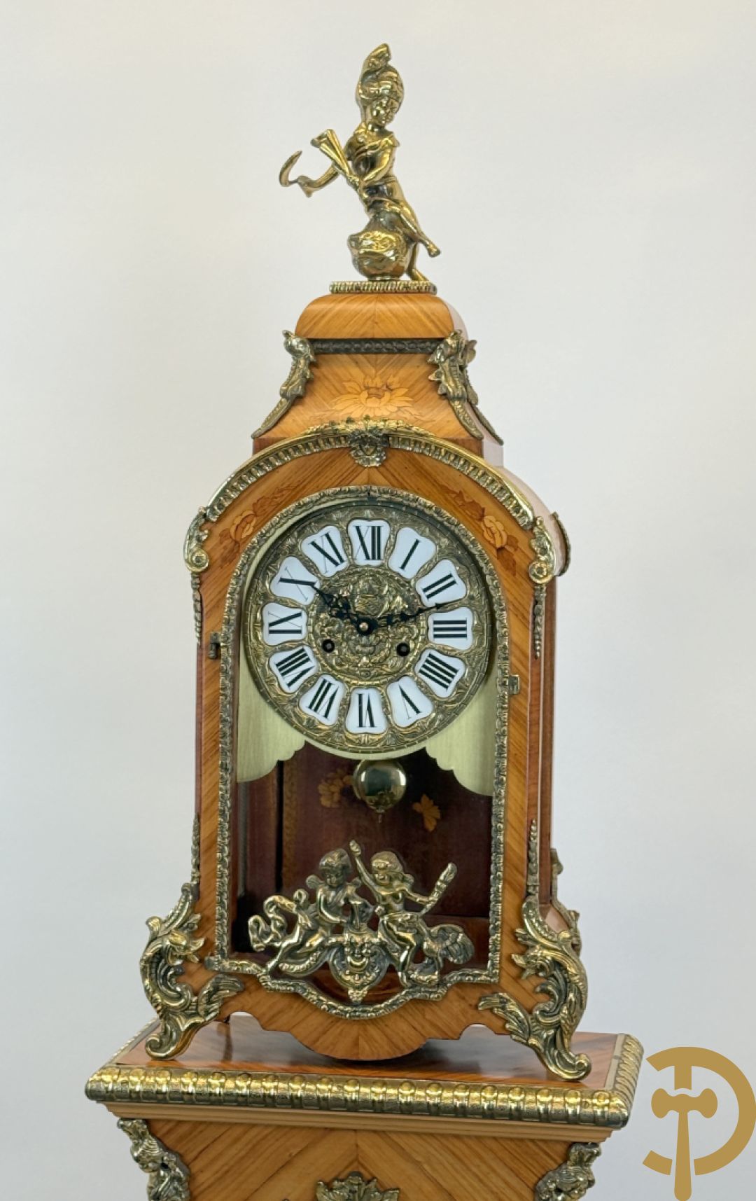 Notelaren pendule met bloemenmarquetterie en bronsbeslag, bovenaan bekroond met bronzen figuur - met bijhorende sokkel in notelaar met bronsbeslag