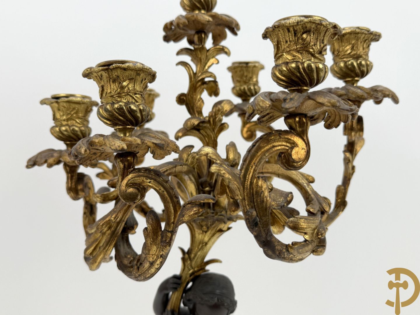 Bronzen cupido dragende een zevenarmige kandelaar