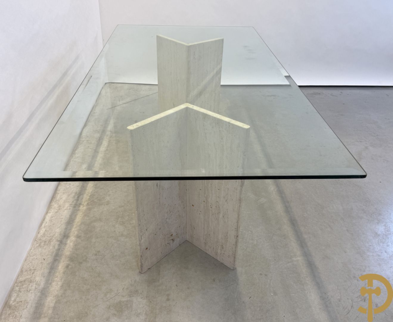 Moderne tafel met geslepen glazen blad op 2 travertin steunen