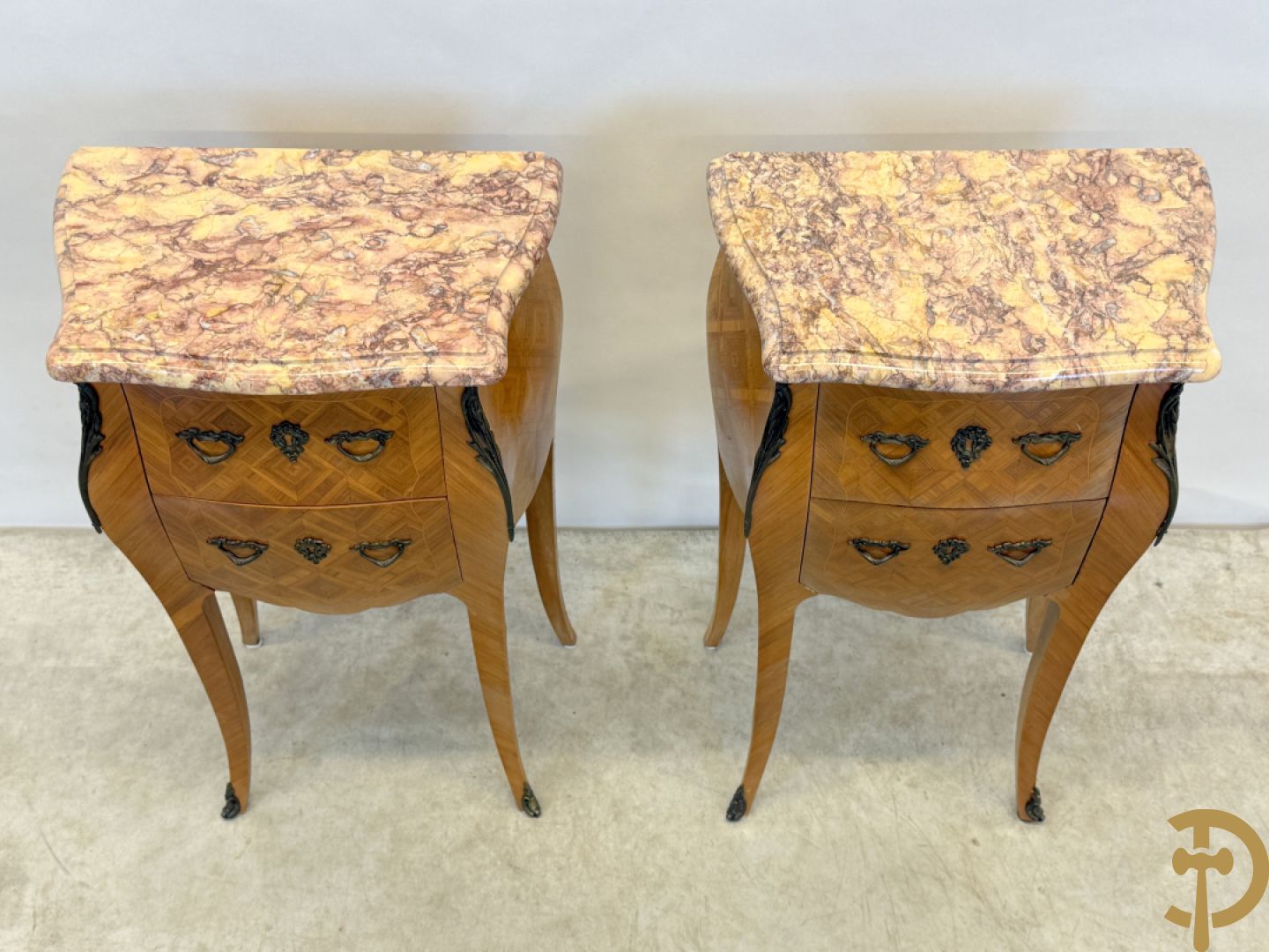 Paar notelaren bijzetkastjes met 2 lades en bezet met bronsbeslag, bovenaan met marmeren blad, op voluutvormige poten