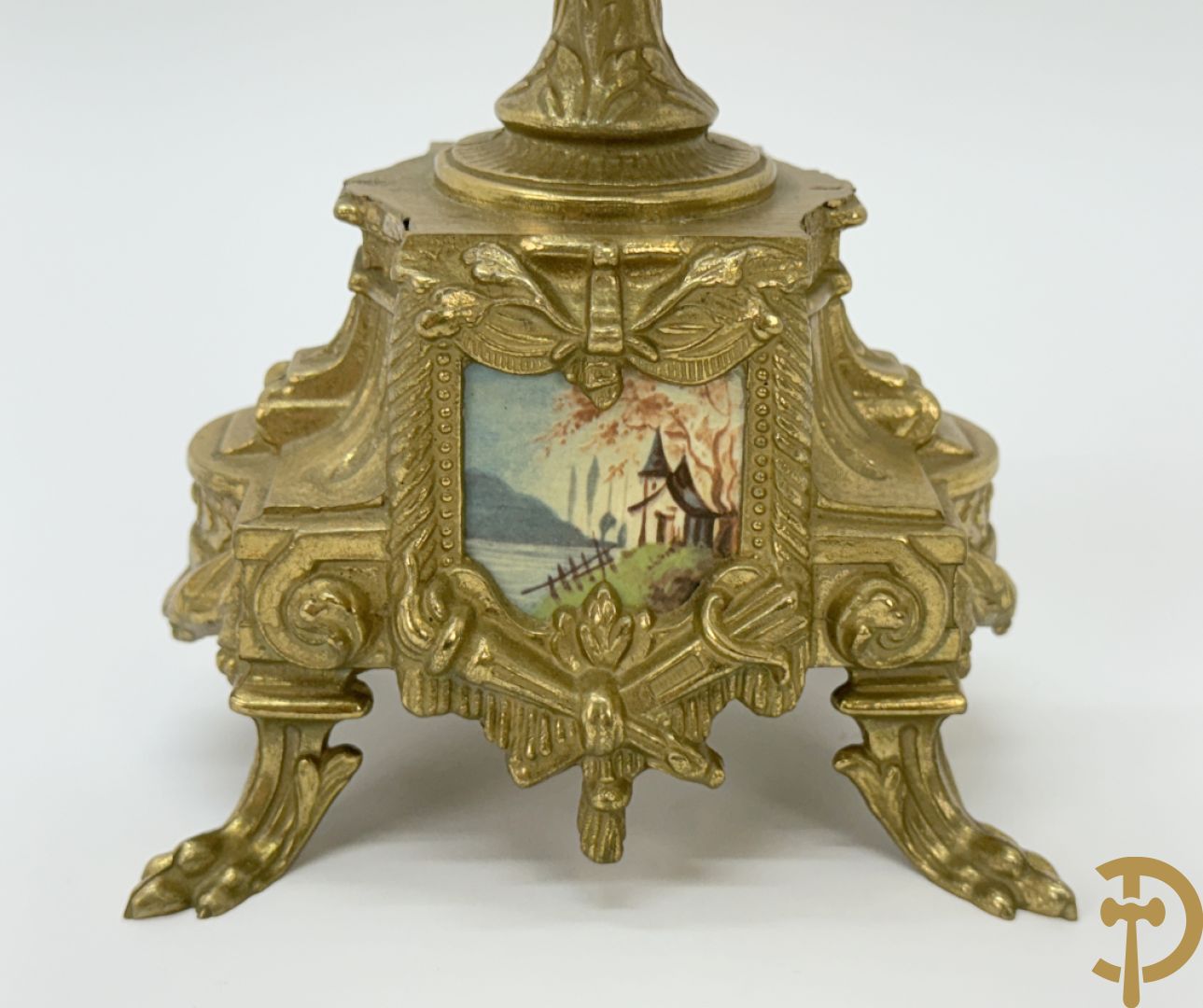 Driedelige koperen garnituur bestaande uit pendule met beschilderd romantisch tafereel en amfoor, zijdelings bezet met paar cassolettes met geanimeerde scènes, onleesbaar getekend rechts onder klok