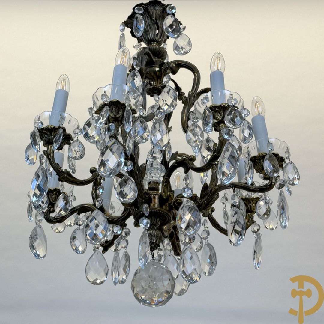 Achtarmige koperen luchter met kristallen bellen en binnenin met pinakel bezet