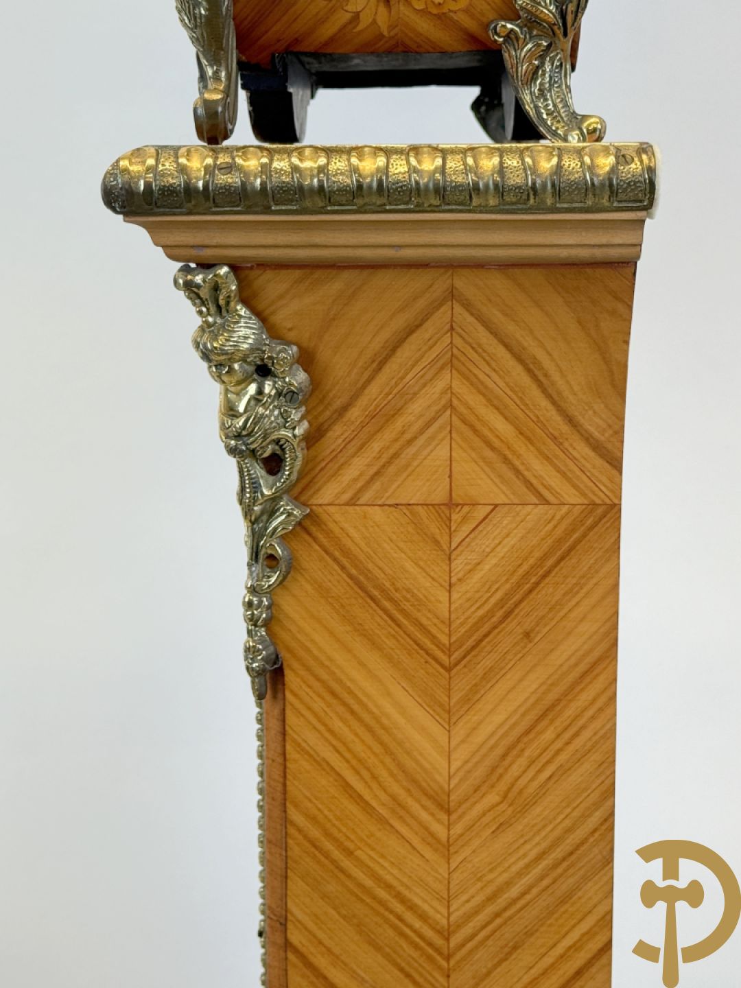 Notelaren pendule met bloemenmarquetterie en bronsbeslag, bovenaan bekroond met bronzen figuur - met bijhorende sokkel in notelaar met bronsbeslag