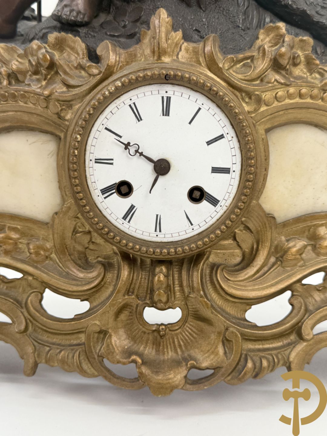 Zamak pendule met accanthusranken en bekroond met cupido met jachthoorn