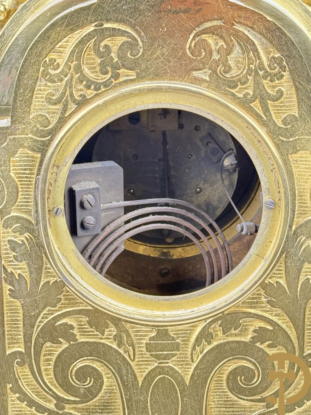 Vuurvergulde bronzen pendule, zijdelings bezet met gevleugelde dames, bovenaan met amfoor