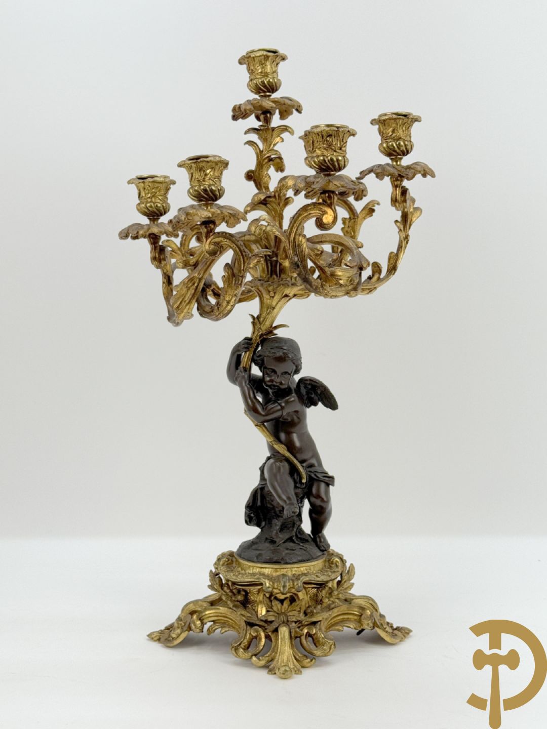 Bronzen cupido dragende een zevenarmige kandelaar