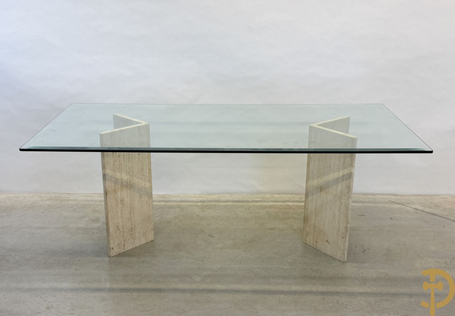 Moderne tafel met geslepen glazen blad op 2 travertin steunen