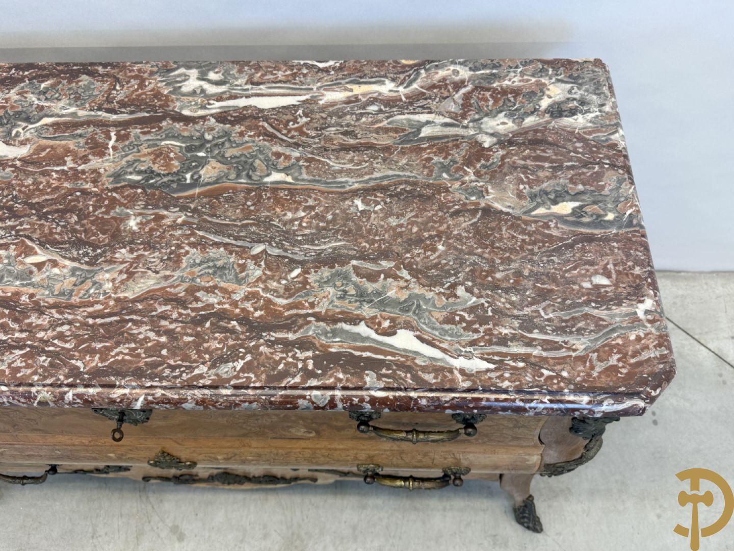 Wortelnotehouten drieladencommode met bronsbeslag van mazarinkoppen en accanthusranken, bovenaan met rood geaderd marmeren blad
