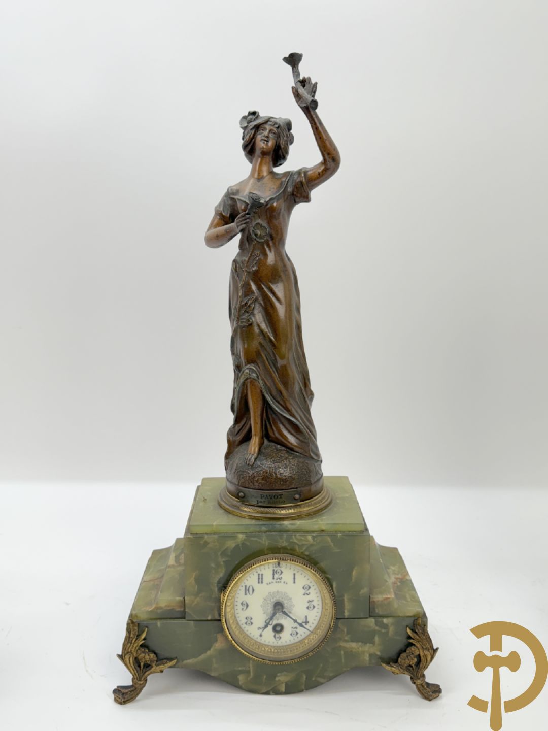 Driedelige zamak garnituur met dame Pavot met bloemen op uurwerk, Rucho getekend, geflankeerd door paar kandelaars