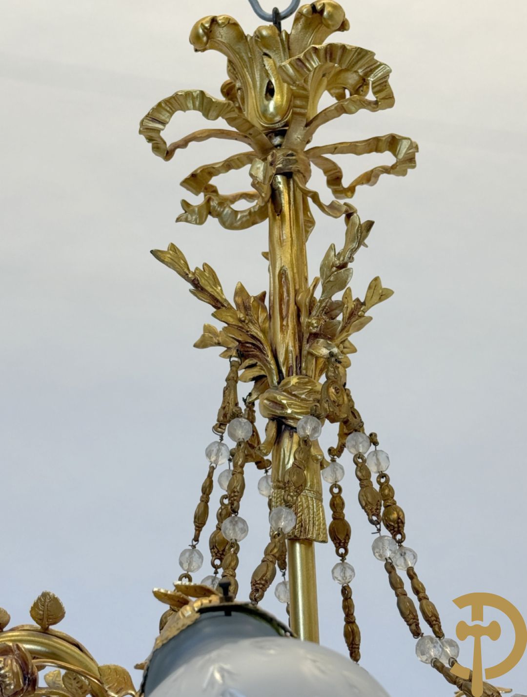 Bronzen vuurvergulde luchter met 4 paar lichtpunten bezet met bladranken, onderaan met glazen schelpen en armen bezet met cupidohoofden