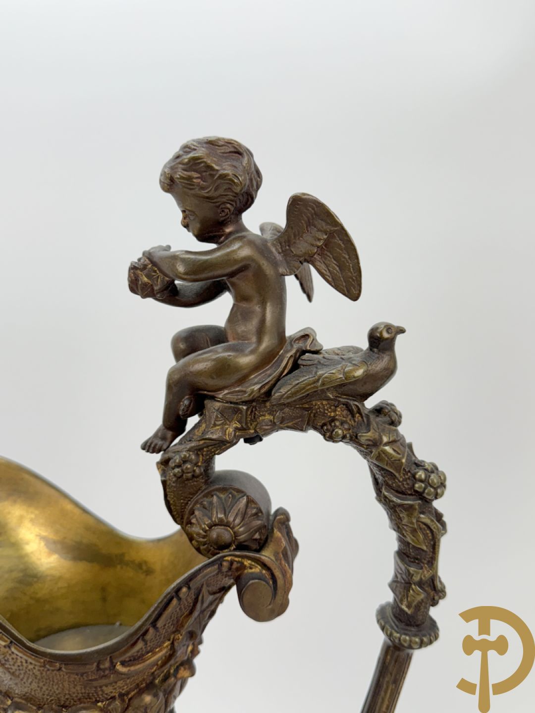 Paar bronzen schenkkannen met basrelief van putti en accanthusranken