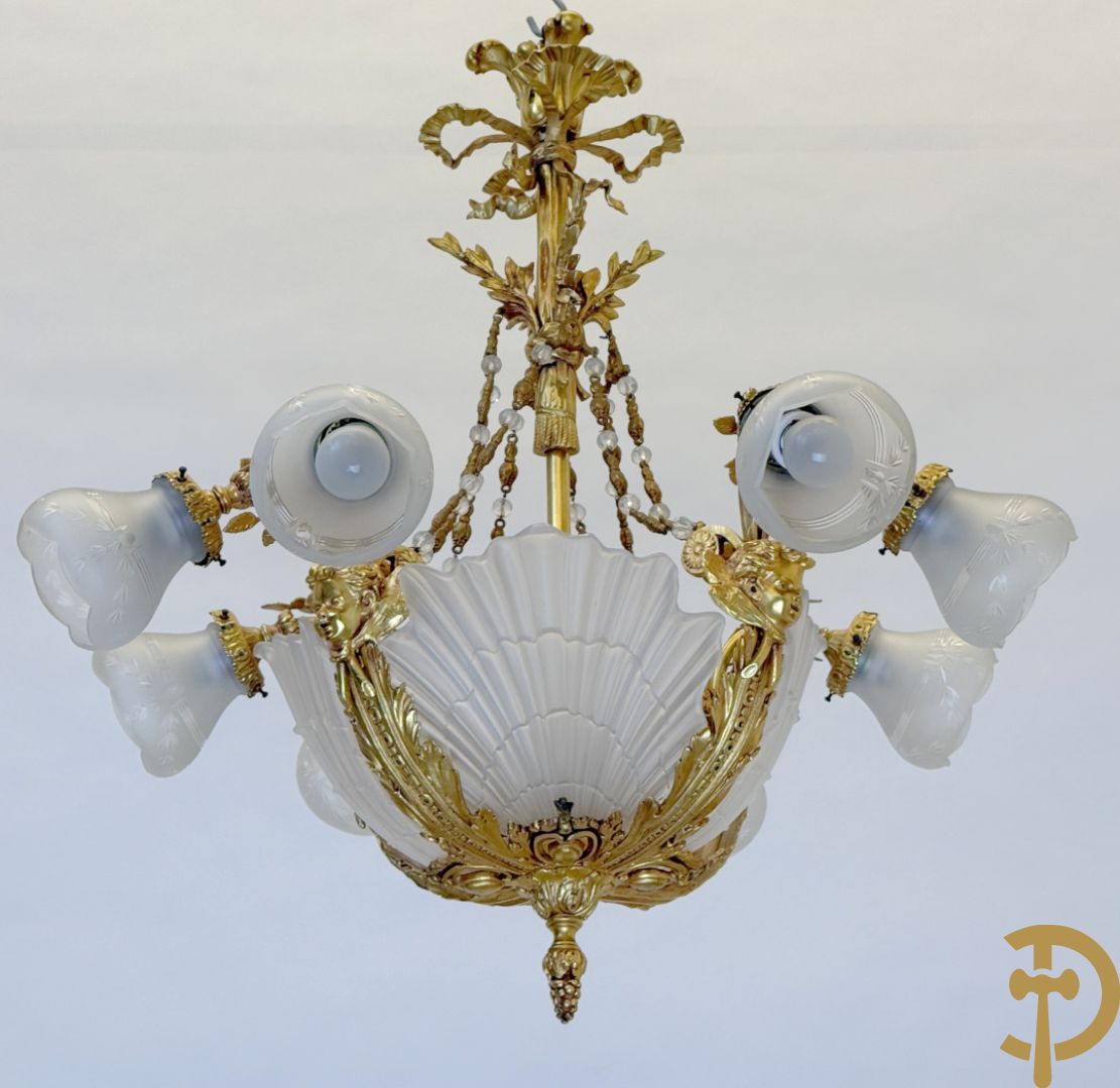 Bronzen vuurvergulde luchter met 4 paar lichtpunten bezet met bladranken, onderaan met glazen schelpen en armen bezet met cupidohoofden