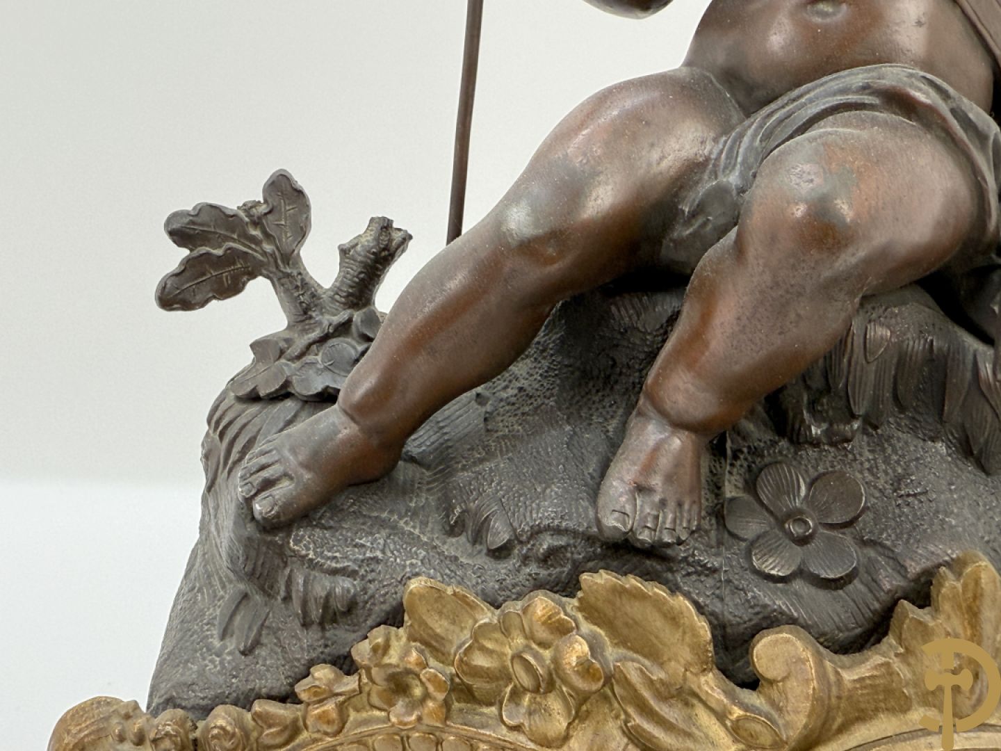 Zamak pendule met accanthusranken en bekroond met cupido met jachthoorn