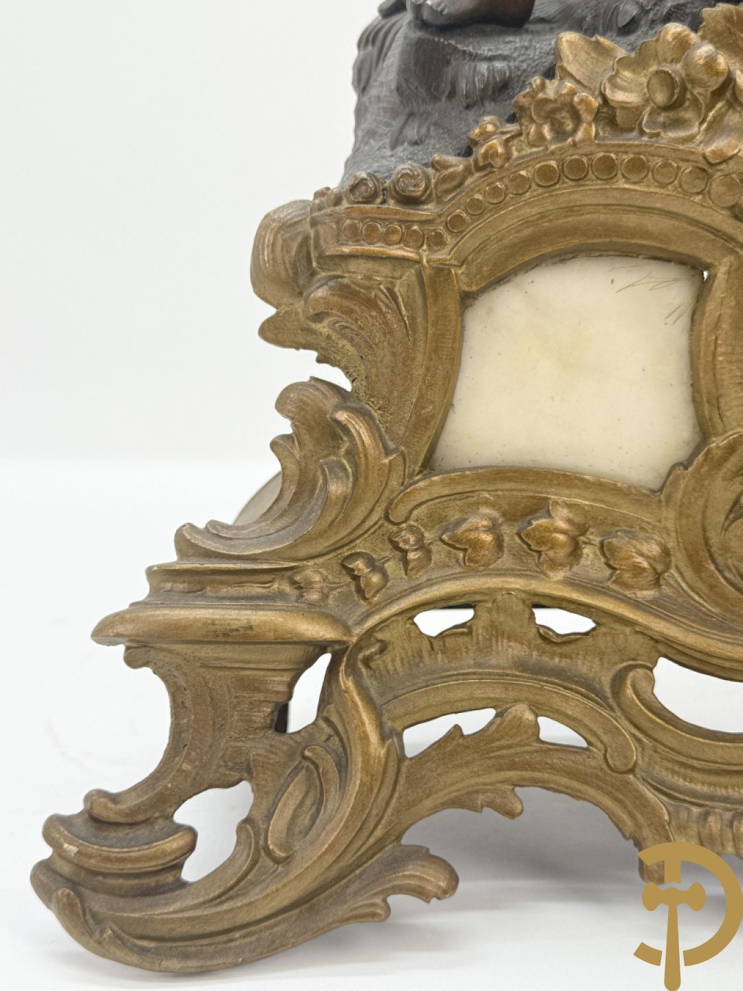 Zamak pendule met accanthusranken en bekroond met cupido met jachthoorn