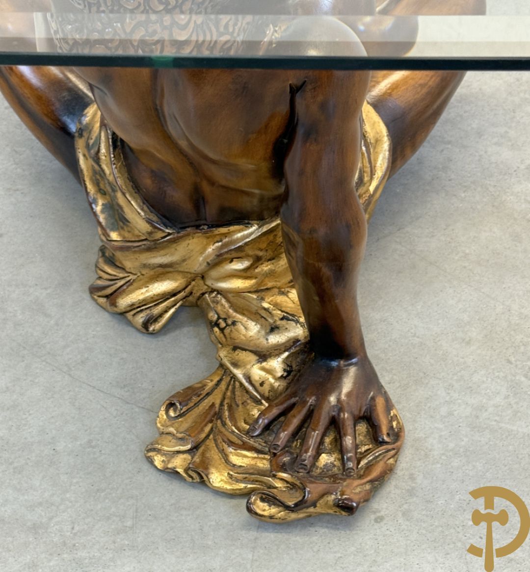 Salontafel met een paar moren met vergulde lendendoek dragende een achthoekig geslepen glazen blad