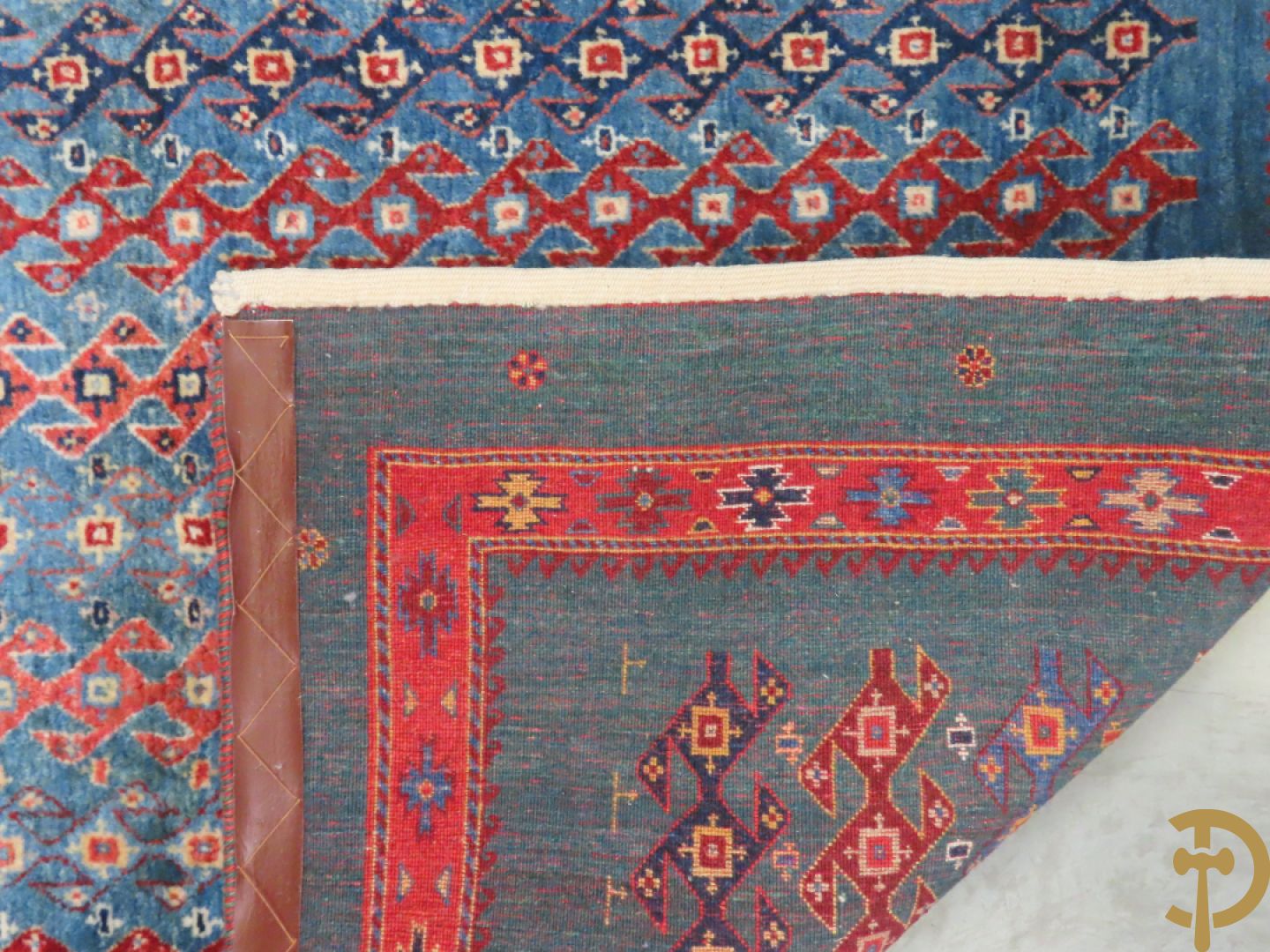 Oosters handgeknoopt tapijt met geometrische patronen op blauwe fond