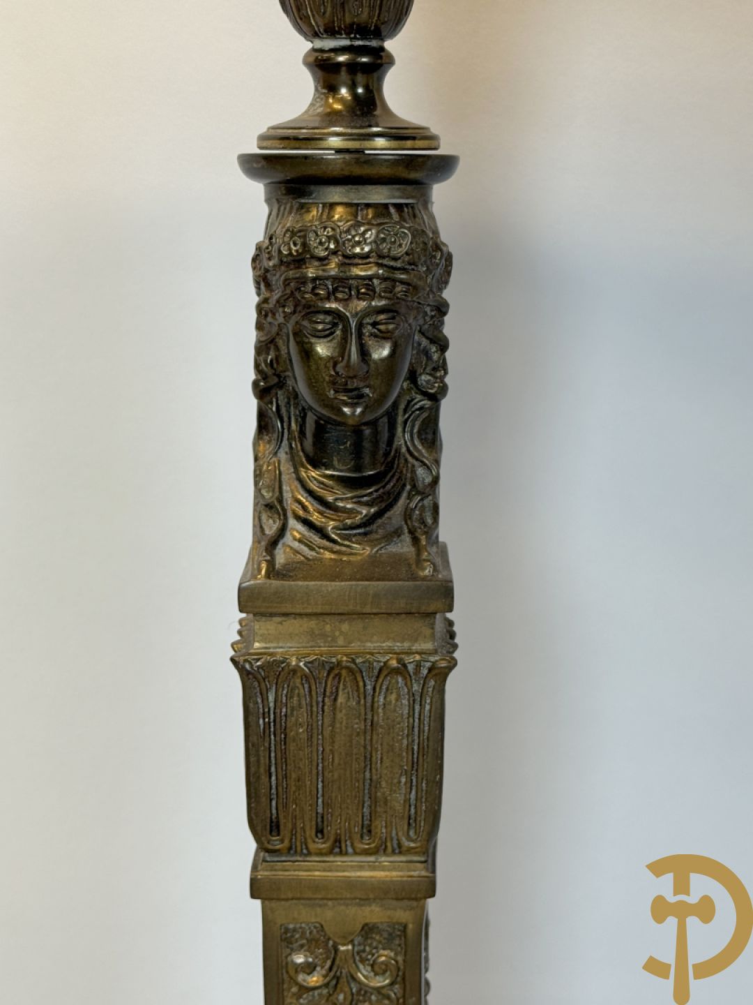 Console op bronzen poten met dameshoofden bezet, bovenaan met groen marmeren blad