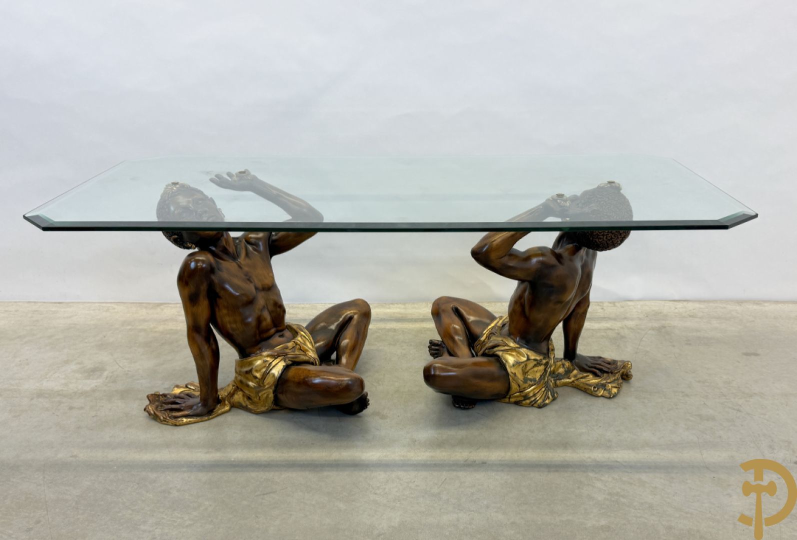 Salontafel met een paar moren met vergulde lendendoek dragende een achthoekig geslepen glazen blad