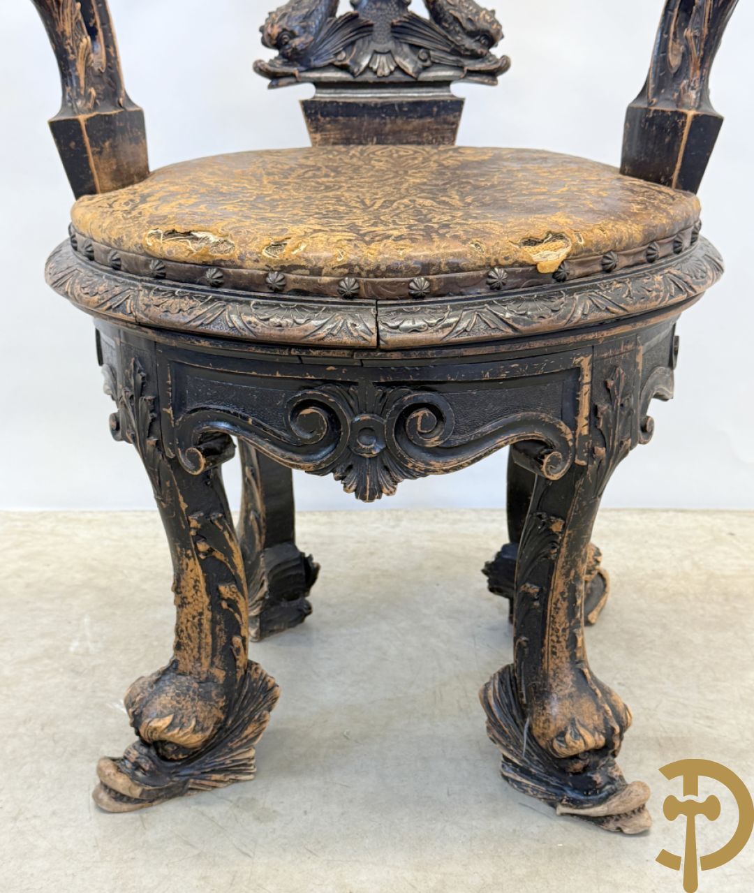 Gesculpteerde draaibare gondelvormige stoel steunend op 4 poten in de vorm van dolfijnen, bovenaan met kariathiden en engelenkoppen