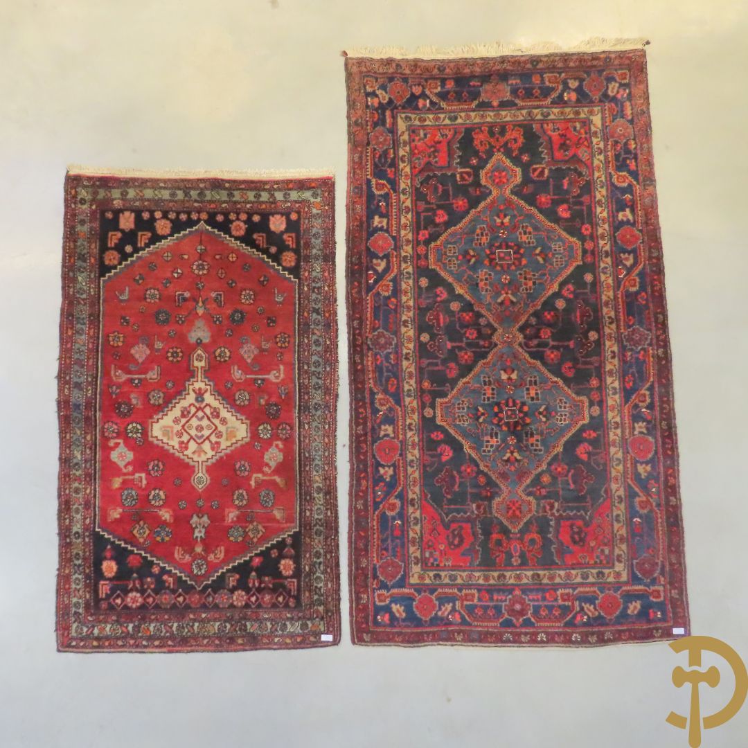 Oosterse handgeknoopt tapijt met geometrische motieven op blauwe fond Malayer + Oosters handgeknoopt tapijt met bloemenpatronen rode fond Kashkay