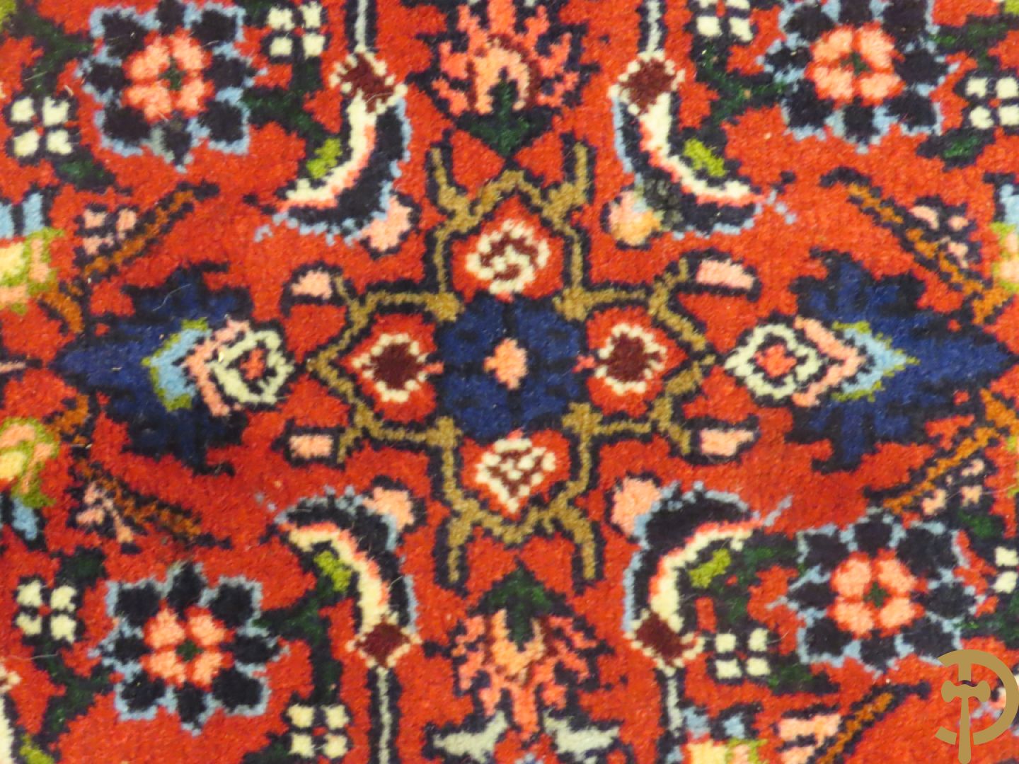 Oosters handgeknoopt tapijt met bloemenpatronen op rode fond