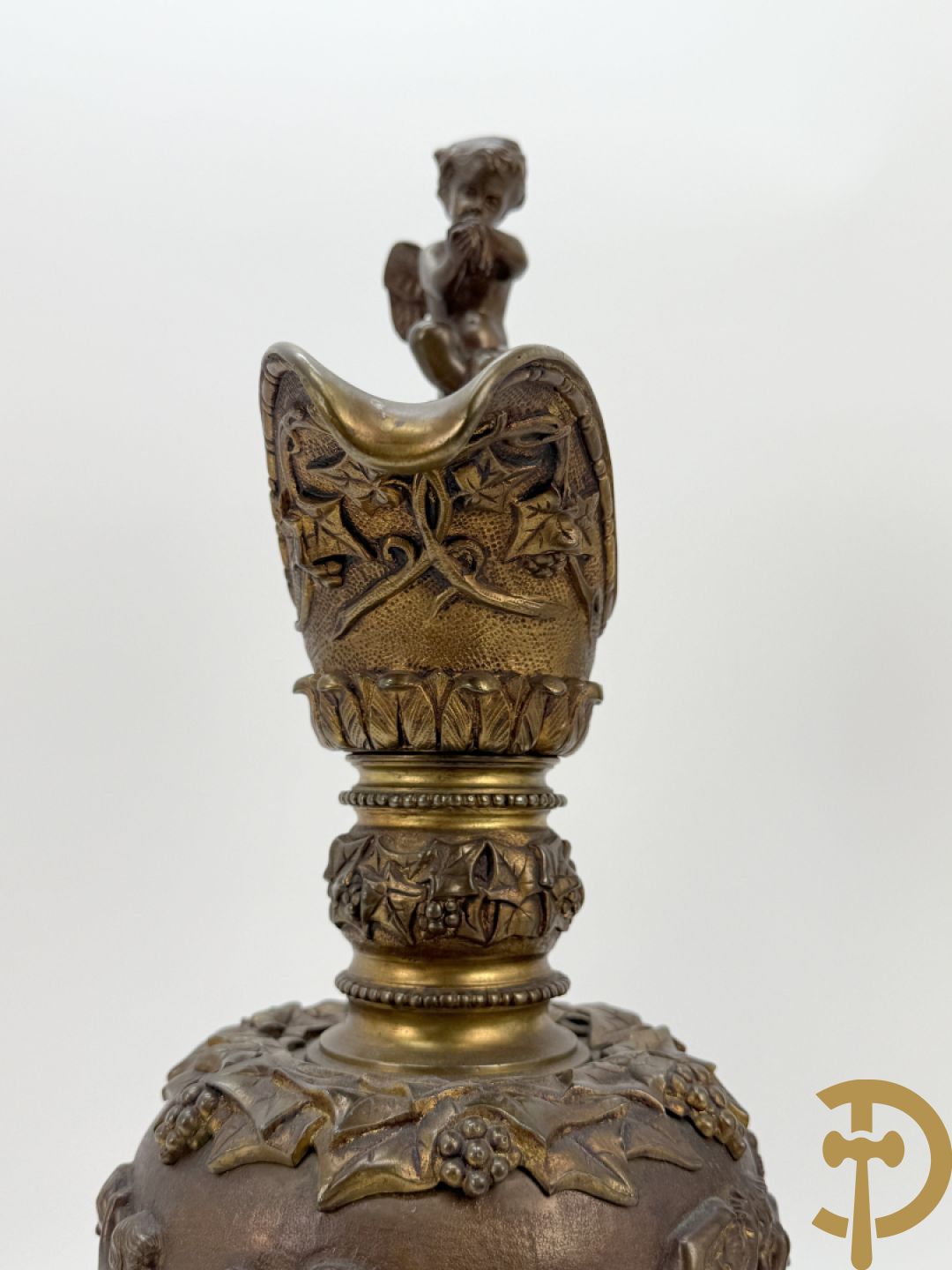 Paar bronzen schenkkannen met basrelief van putti en accanthusranken