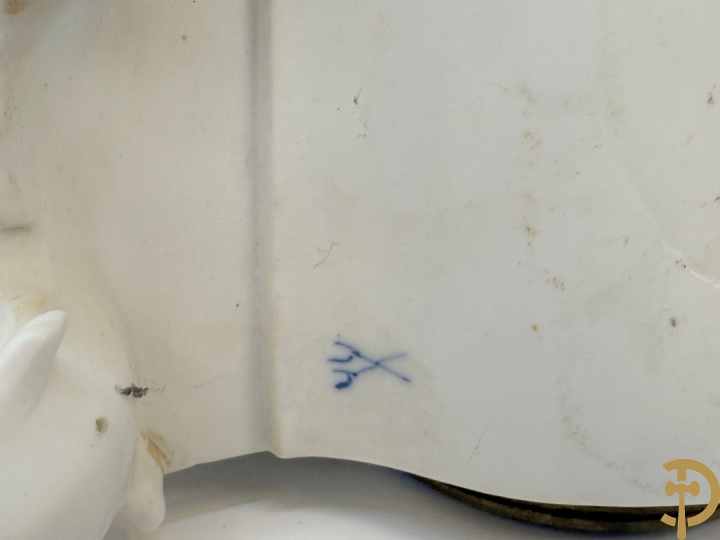 Driedelige porseleinen garnituur bestaande uit pendule bezet met lieftallig koppel, geflankeerd door paar kandelaars met cupido