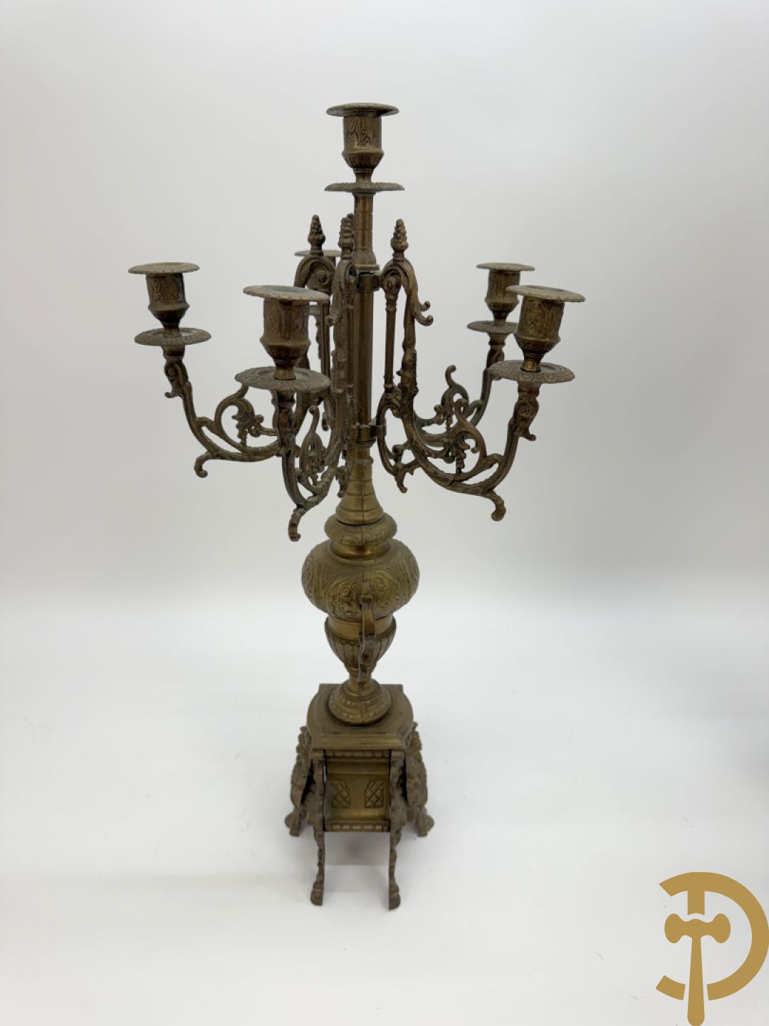 Driedelige koperen garnituur, klok geflankeerd door paar vijfarmige kandelaars