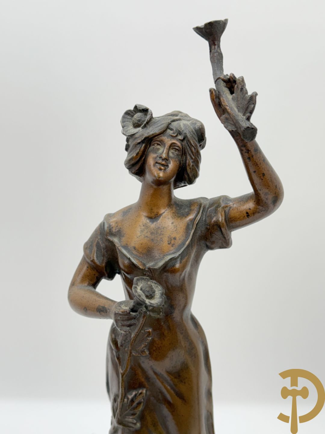 Driedelige zamak garnituur met dame Pavot met bloemen op uurwerk, Rucho getekend, geflankeerd door paar kandelaars