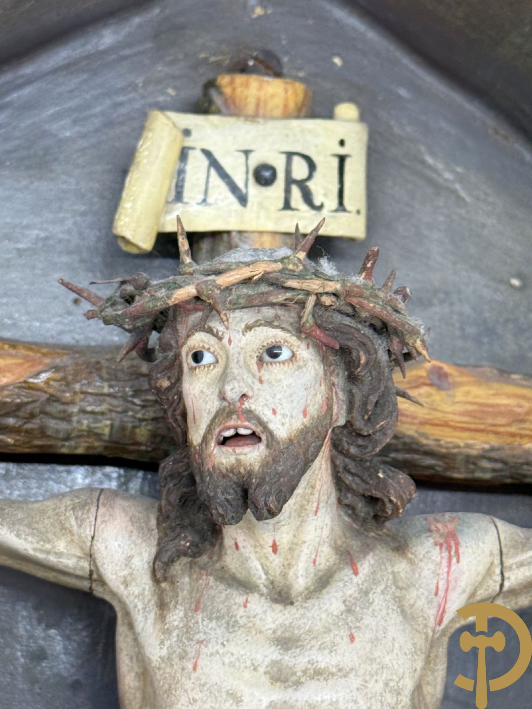 Houtgesculpteerde en gepolychromeerde Christus aan het kruis in openklapbaar gespolychromeerd kastje